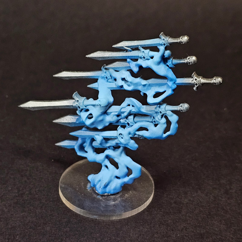The Used Warhammer Age of Sigmar: Quicksilver Swords Endless Spell is a table-ready miniature with five silver blades emerging from swirling blue shapes on a clear round base, shown against a black background.