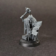 Used Warhammer Age of Sigmar: Flesh Eater Courts - Grand Justice Gormayne: A gray mini of the skeletal, robed mage with staff, beside an open book on a stand, scrolls and books at his feet on a round base.