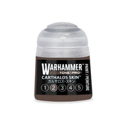 A small, round Warhammer Tone Pro plastic bottle of dark brown paint with a translucent cap and a label reading Carthalos Skin and a series of numbered circles from 1 to 5.