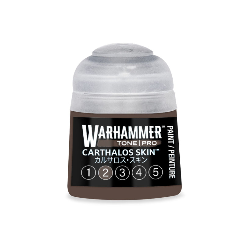 A small, round Warhammer Tone Pro plastic bottle of dark brown paint with a translucent cap and a label reading Carthalos Skin and a series of numbered circles from 1 to 5.