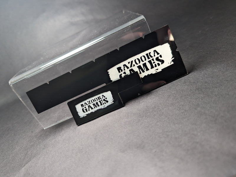 The Bazooka Games Movement Tool Bundle has two black razor blades with "BAZOOKA GAMES" in white, upright on grey, case behind.