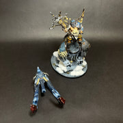 A used Warhammer Age of Sigmar: Ogor Mawtribes - Huskard on Thundertusk miniature, painted and displayed on a snowy base, stands next to a separate blue-armored, legless figure lying on the black background.
