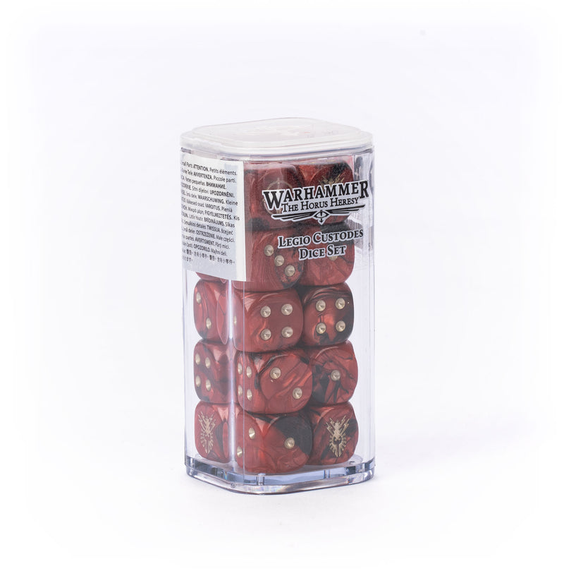 A clear plastic box holding the Horus Heresy: Legio Custodes - Dice Set, featuring red dice with gold pips and Legio Custodes symbols, is neatly stacked on a white background.