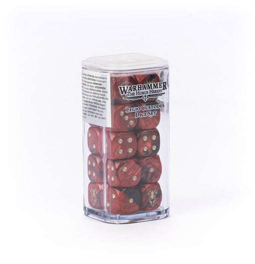 A clear plastic box holding the Horus Heresy: Legio Custodes - Dice Set, featuring red dice with gold pips and Legio Custodes symbols, is neatly stacked on a white background.