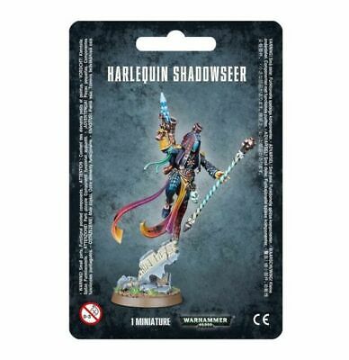 A packaged Warhammer 40k: Aeldari Shadowseer miniature shows a colorful masked figure with staff and pistol on a detailed base.