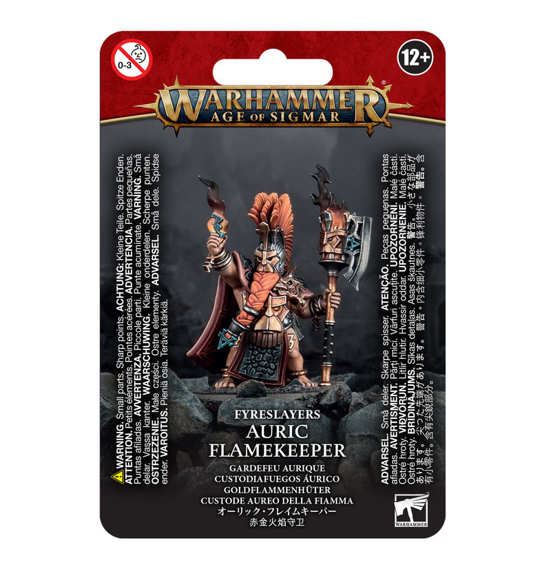 A packaged Warhammer Age of Sigmar Fyreslayers: Auric Flamekeeper miniature with a large axe, bright crest, and warning labels.