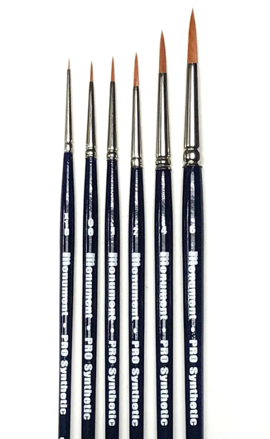 The Monument Hobbies Pro Synthetics Paint Brush Set of 6 features fine-tipped brushes with dark blue handles, arranged side by side in increasing size against a white background.