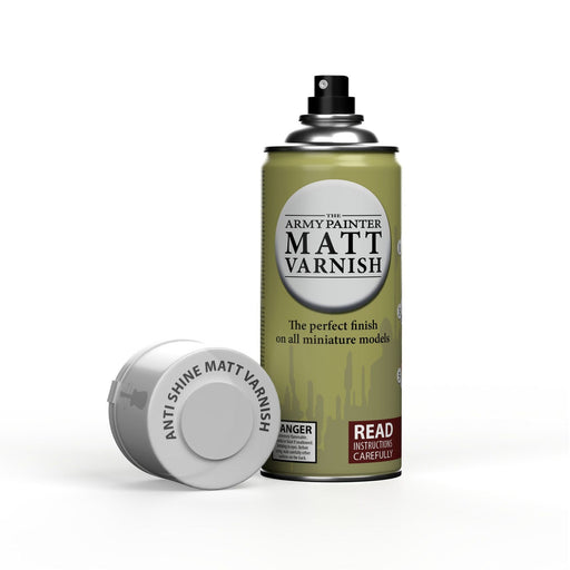 A 400ml can of Army Painter Color Primer Spray Paint, featuring a detached cap labeled “Anti-Shine Matt Varnish.” Ideal for hobby miniatures; the can reads “The perfect finish on all miniature models” and “Read instructions carefully.”.