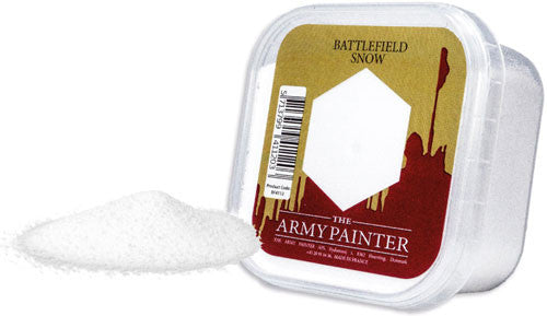 The Army Painter: Battlefield Snow (150ml) clear plastic container sits beside a pile of white powder for winter miniature bases.
