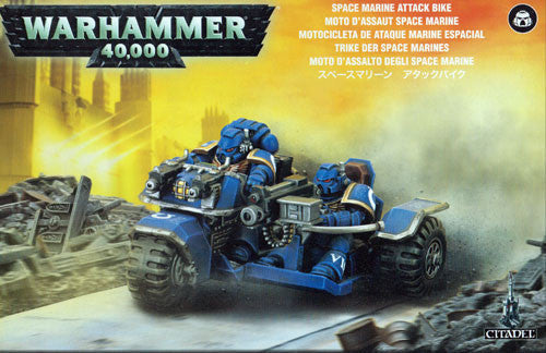Two blue-armored Space Marines ride a futuristic Attack Bike through a rubble-strewn warzone. The box shows "Warhammer 40k: Space Marine Attack Bike" in several languages and highlights Games Workshop miniatures.