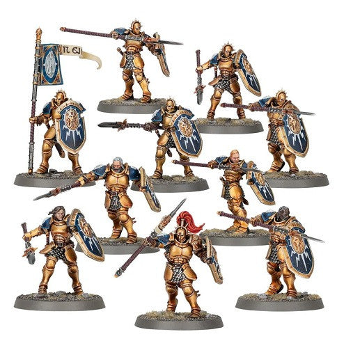 Ten Stormcast Eternals Vindictors, painted gold with shields and weapons, stand on round bases; one holds a banner, one has a red plume.
