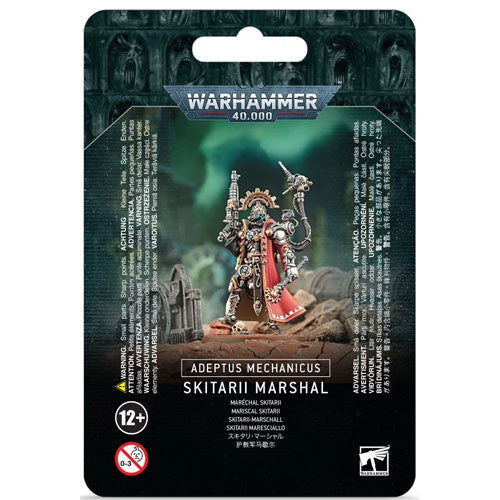 The front of the Warhammer 40k: Adeptus Mechanicus - Skitarii Marshall kit shows the painted figure before a ruined sci-fi backdrop, with a 12+ age rating and visible safety warnings.